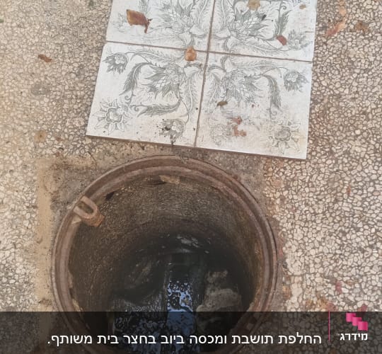 פתח ביוב פתוח עם מים בתוכו